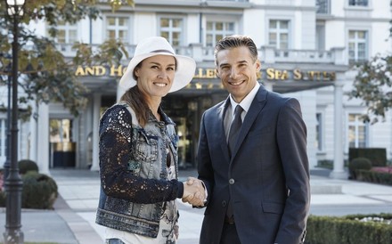 Patrick Vogler und Martina Hingis vor einem Grand Hotel Resort