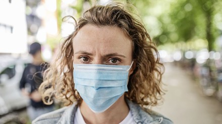 junge Frau mit Mund-Nasenschutz
