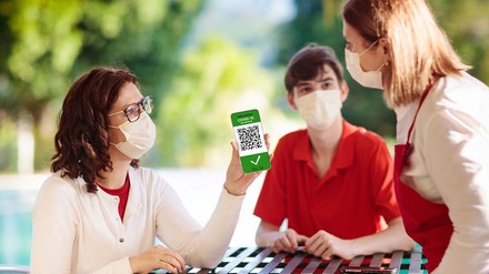 Mutter zeigt im Café ihren Impfnachweis vor