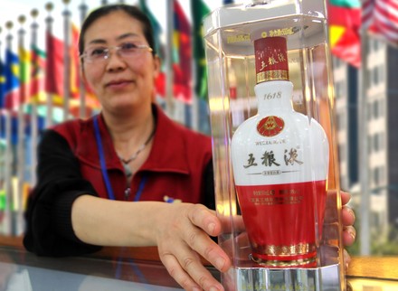 Eine Asiatin präsentiert eine hochwertige Flasche chinesischen Schnaps