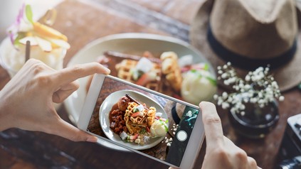 Frau schießt Bild von Essen mit Smartphone