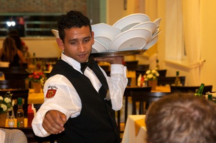 Ein Kellner balanciert ein Tablett mit vielen Tellern