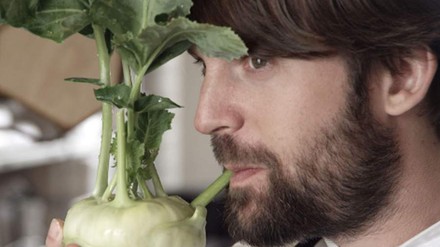 Ein Mann beißt in einen Kohlrabi