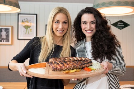 Yvonne Rueff und Kimberly Budinsky halten ein Holzbrett mit Rippchen