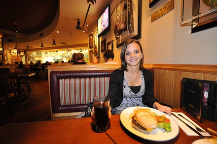 EIne junge Dame mit Burger in einem Hard Rock Cafe