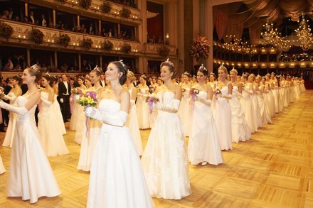 Viele junge Frauen in weißen Kleidern stehen in Reih und Glied in der wiener Staatsoper beim Opernball