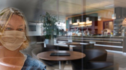 Eine Frau mit Mundschutz im Restaurant