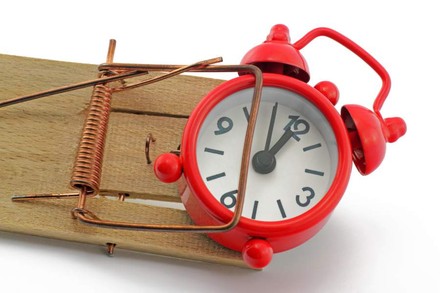 Ein Wecker steckt in einer Mausefalle fest