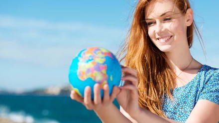 Junge Frau mit Globus in der Hand