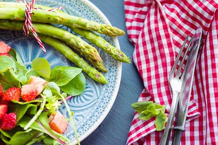 Ein Teller mit Spargel und frischem Salat mit Kräutern