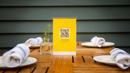 Ob digitale Speisekarte oder Mobile Payment – die Corona-Pandemie hat die Digitalisierung in Hotellerie und Gastronomie beschleunigt. (Foto: © Kathy images – stock.adobe.com)
Aufsteller mit QR-Code für die Speisekarte auf dem gedeckten Tisch