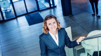 Junge Frau im Businessanzug steigt eine Treppe herauf