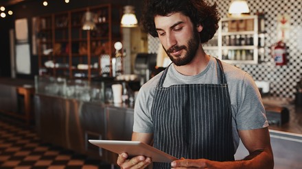 Junger Kellner mit Tablet