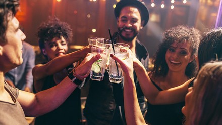Freunde stoßen mit Getränken im Club an