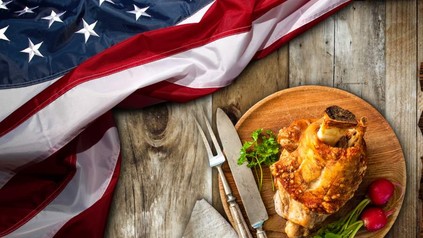 Eine us-amerikanische Fahne liegt neben einem Teller mit Schweinshaxe