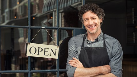 Gastronom an der Eingangstür mit Open-Schild
