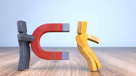 Ein Männchen auf Metall zieht ein anderes Männchen mit einem Magneten an