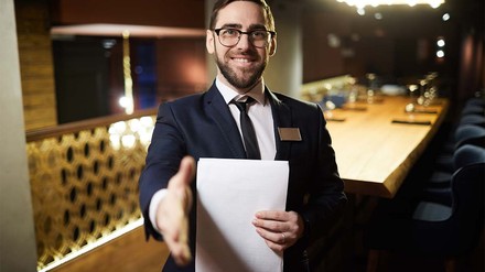 Restaurant Manager streckt Betrachter die Hand entgegen