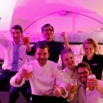 Gruppe prostet mit Bier in Kamera