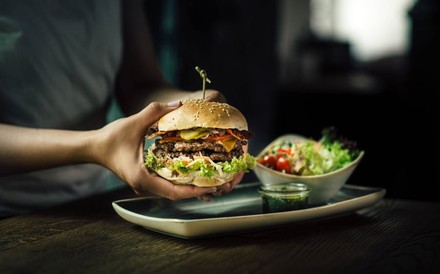 Mit seinen individuell konzipierbaren Burgern will sich Le Burger von den US-Fastfood-Ketten abheben. (© Le Burger)
Eine Person richtet einen Burger auf einem Teller mit Salat an