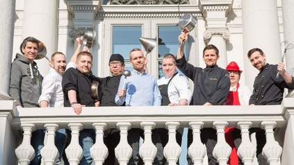 Mario Bernatovic, Marcel Ruhm, Felix Albiez, Hiroshi Sakai, Oliver Lucas, Jürgen Gschwendtner, Fabian Philler, Harald Brunner und Lukas Olbrich auf einer Empore mit Töpfen und Kellen in den Händen