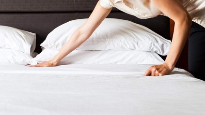 Ein Zimmermädchen beim Bettenmachen