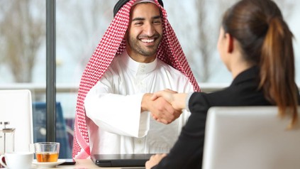 Arabischer Geschäftsmann reicht Frau die Hand