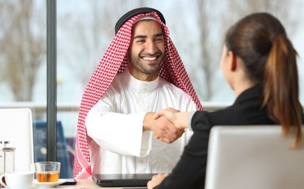 Arabischer Geschäftsmann reicht Frau die Hand