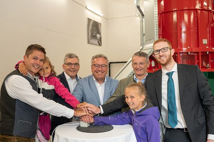 Eine Gruppe Menschen vor einem Wasserkraftwerk