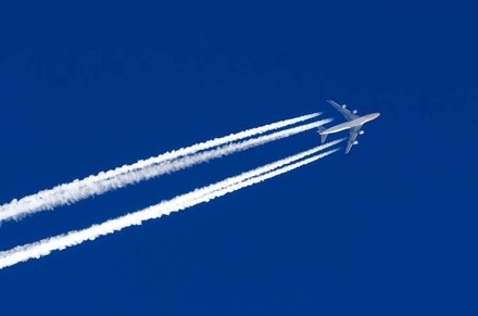 Ein Flugzeug im Himmel erzeugt Kondensstreifen