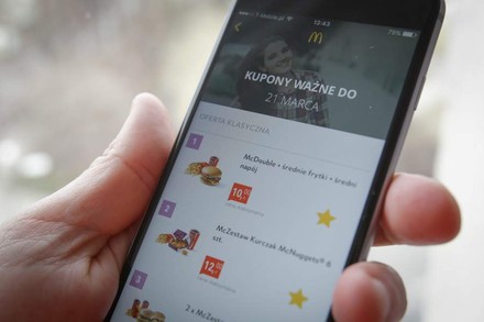 Eine Hand hält ein Smartphone auf dem die McDonald´s App geöffnet ist