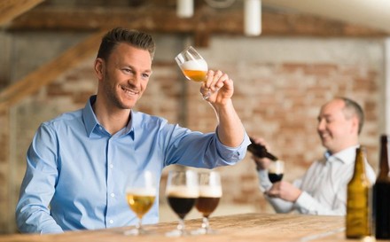 Mann schwenkt Bier im Glas