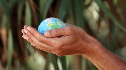 Hände halten eine Weltkugel