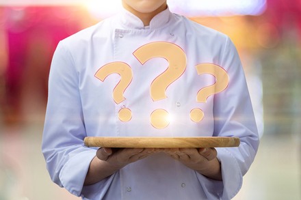 Ein Koch serviert ein Fragezeichen auf einem Tablett