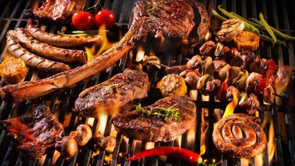 Ein Grill mit diversen Fleischspeisen darauf