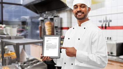 Ein Koch mit einer Bewerbung in der Hand