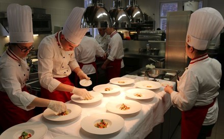 Junge Köche richten mehrere Gerichte auf Tellern an