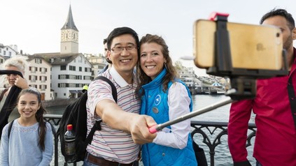 Paar fotografiert sich mit Selfie-Stick auf Brücke