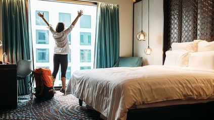 Eine Frau bezieht ihr Hotelzimmer