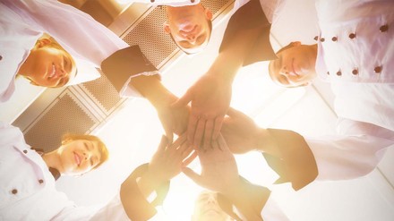 Um Mitarbeiter im Unternehmen zu halten, sollte ihnen vom ersten Tag an Wertschätzung entgegengebracht werden. (Foto: © vectorfusionart – stock.adobe.com)
Mitarbeiter tuen ihre Hände in der Mitte zusammen