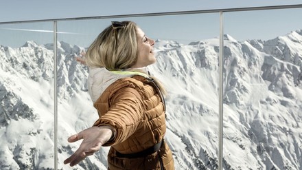 FRau genießt die Sonne auf einer Bergterrasse