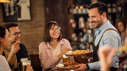 Kellern serviert Gästen Essen