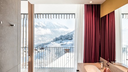 Von der Panorama Suite genießen Gäste des Falkensteiner Hotels Montafon einen beeindruckenden Blick auf die verschneite Skipiste.