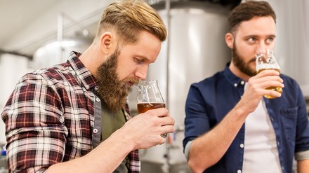 Zwei Männer in einer Brauerei bei der Bierverkostung.