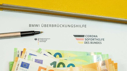Antrag für die Überbrückungshilfe und 50- bzw. 100-Euro-Scheine