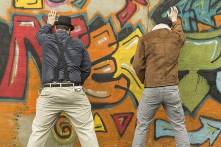 Zwei Männer pinkeln an eine Wand