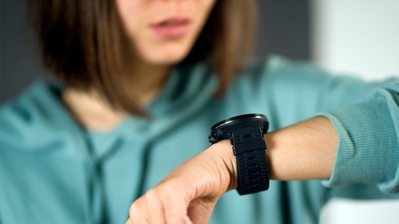 Eine Frau schaut nervös auf ihre Armbanduhr.