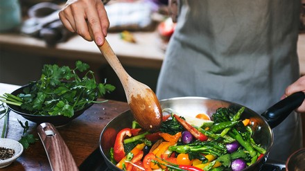 Vegane Gemüsepfanne ist auch etwas Feines. (Foto: © Rawpixel.com/stock.adobe.com)
Eine Frau kocht ein veganes Gericht,