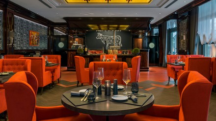 Das Restaurant sorgt mit roten opulenten Samtsesseln, dunklen hochwertigen Holzwänden und nostalgischen Art-Déco-Lampen für ein extravagantes Ambiente. (Foto: © JW Marriott Berlin) JW Steakhouse Berlin