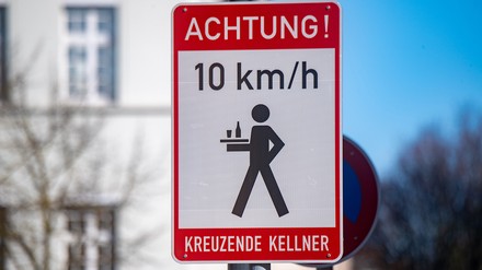 Ein Schild mit dem Schriftzug „Achtung! kreuzende Kellner“ steht in der Peenstraße am Marktplatz von Anklam. (Foto: © picture alliance/dpa | Stefan Sauer) Ein Schild mit dem Schriftzug „Achtung! kreuzende Kellner“ steht in der Peenstraße am Marktplatz von Anklam. (Foto: © picture alliance/dpa | Stefan Sauer)